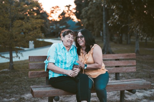 Mother and Daughter on a park bench laughing